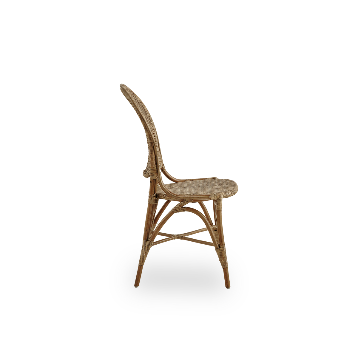 Vista lateral de la silla de comedor Rossini en color marrón antiguo. Elegante silla de mimbre con respaldo redondo de diseño sencillo. Hecha a mano con ratán de alta calidad.