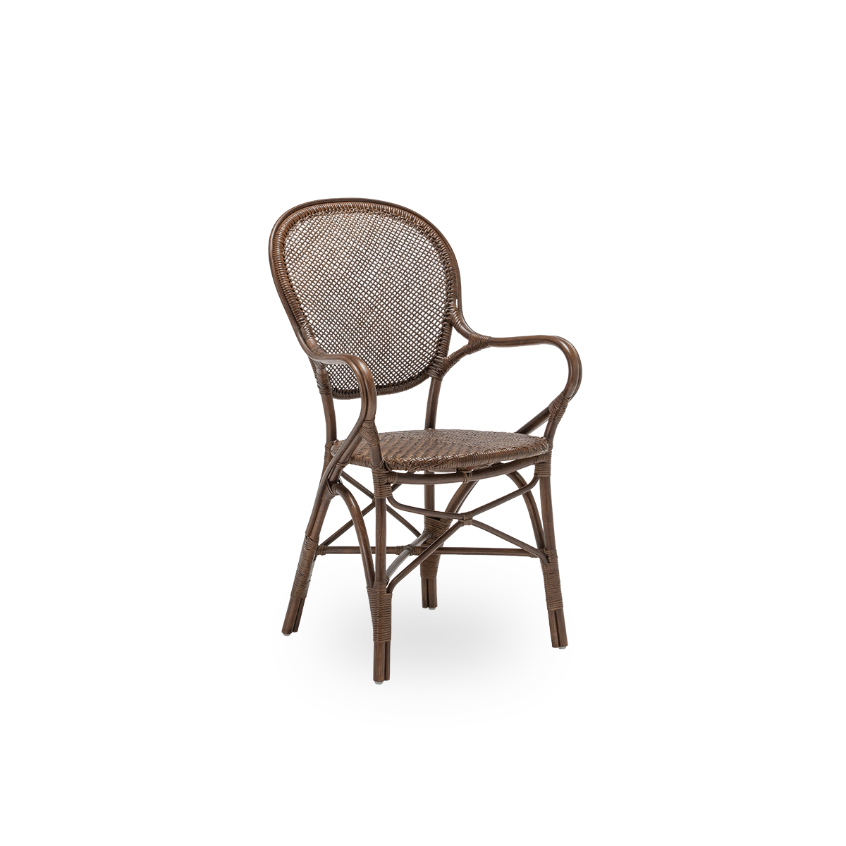 Vista lateral del sillón de comedor Rossini, en ratán marrón. Diseñada en 1993 por Knud Andreasen de Sika-Design junto al diseñador japonés Yamakawa, es la silla insignia de la casa. Hecha a mano con ratán de Indonesia de alta calidad.