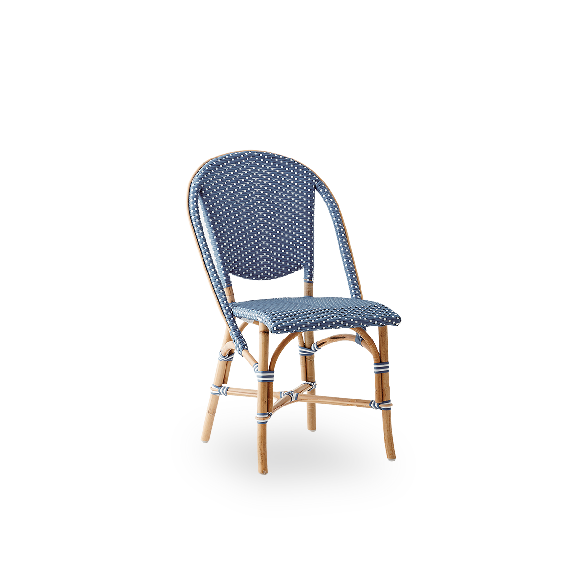 Vista lateral de la silla de comedor Sofie de ratán, inspirada en el estilo de café francés. Estructura de ratán con asiento y respaldo completamente tejidos, hechos a mano en ArtFibre azul con patrón de puntos blancos. Silla bistró de ratán apilable.