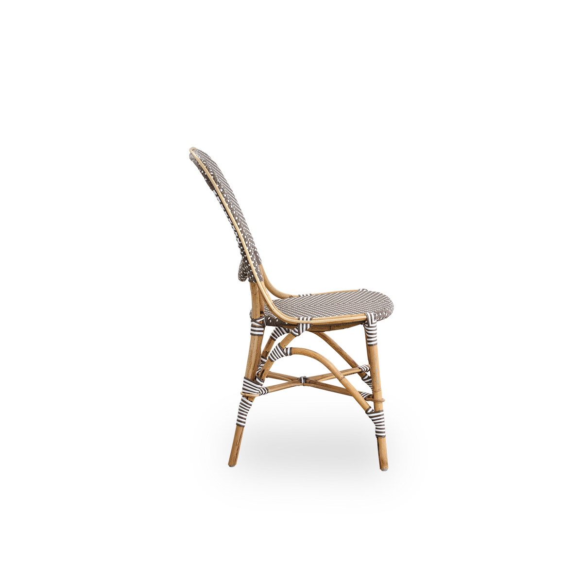 Vista lateral de la silla de comedor Isabell. Estructura de ratán con asiento y respaldo en ArtFibre marrón con puntos blancos. Inspirado en el diseño de bistró de los años 50.