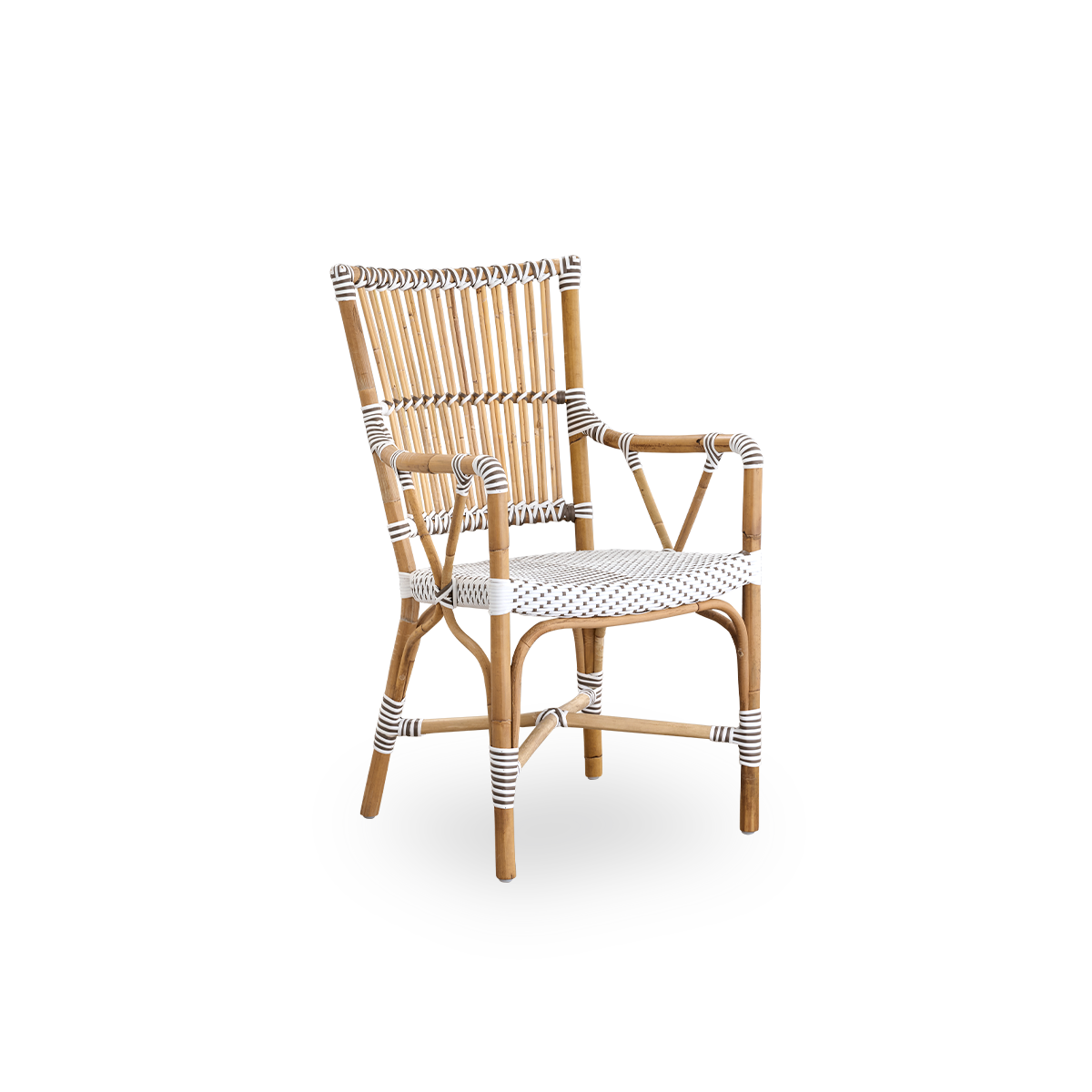 Vista lateral de la silla de comedor con brazos Monique. Estructura de ratán con asiento tejido en ArtFibre blanco con puntos marrones. Inspirada en el diseño de bistró de los años 50.