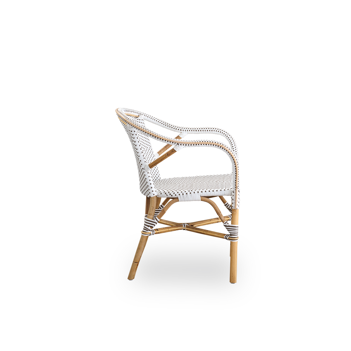 Vista lateral de la silla de comedor Madeleine con reposabrazos. Estructura de ratán con asiento y respaldo en ArtFibre blanco con puntos marrones. Inspirado en el diseño de bistró de los años 50.