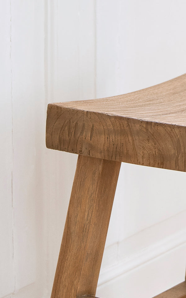 Esta es una imagen de detalle de Charles taburete en teak indoor.