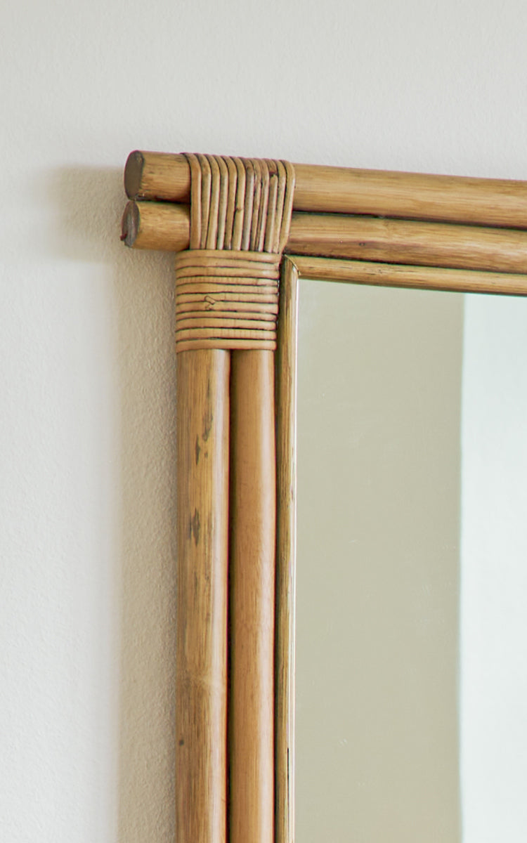 Esta es una imagen de detalle de Rasmus Mirror 172 cm en antique rattan. Detalle de las varas de ratán agrupadas y esquina envuelta del marco del espejo.