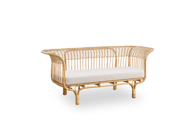Vista lateral del sofá Belladonna en ratán natural, diseñado por Franco Albini y Franca Helg. El sofá tiene una expresión elegante con patas delgadas y un asiento majestuoso con numerosos detalles de tejido.