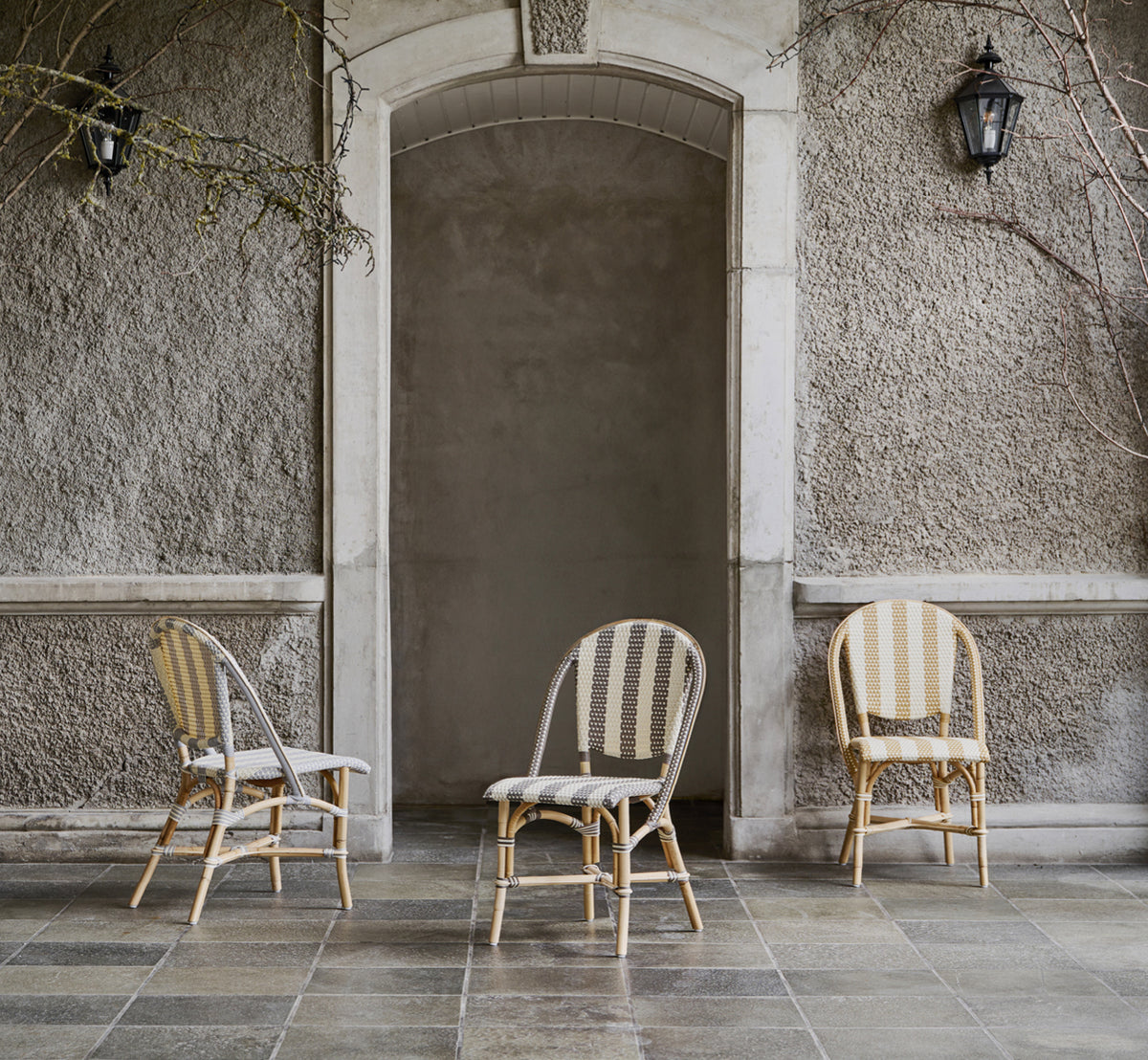 Esta es una imagen de estilo de vida de Sofie silla de comedor en striped grey ivory artfibre skin on natual rattan frame. Estilizado en un interior luminoso.