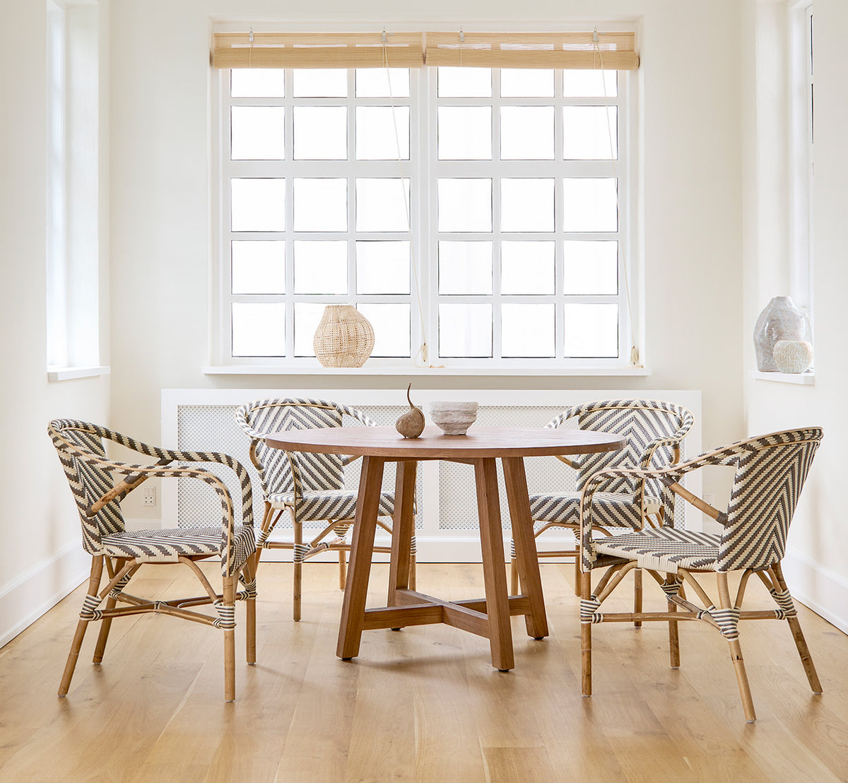 Esta es una imagen de estilo de vida de Aksel mesa de comedor en teak indoor, en un luminoso comedor con grandes ventanas y suelo de madera clara.