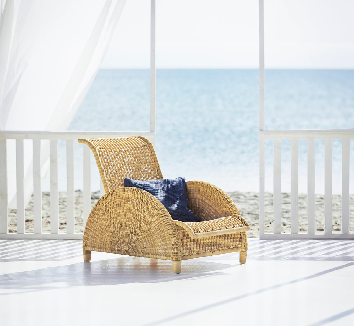 Esta es una imagen de estilo de vida de Paris sillón lounge exterior en natural core weave artfibre aluminium. Estilizado en un interior luminoso.
