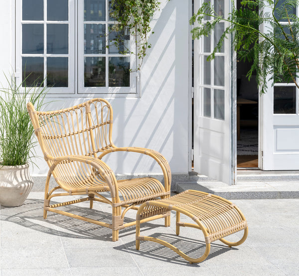 Esta es una imagen de estilo de vida de Teddy reposapiés exterior en natural aluminium artfibre. Combinado con el sillón lounge a juego en una terraza pavimentada soleada.