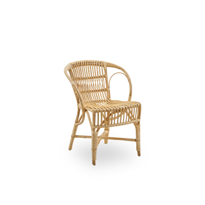 Vista lateral de la silla de comedor Robert en color Natural, diseñada por Robert W. Elegante silla de mimbre hecha a mano con ratán de alta calidad de Indonesia.