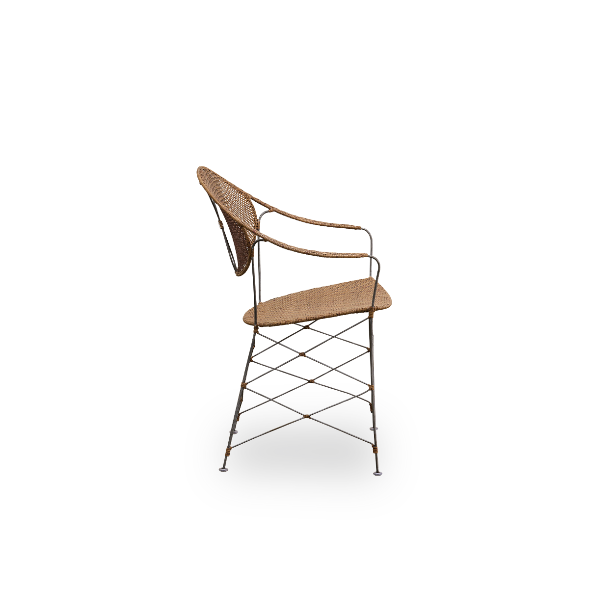 Vista lateral de la silla de comedor Funky, diseñada por Yuzuru Yamakawa. La silla tiene una estructura de acero con asiento y respaldo tejidos a mano en ratán indonesio de alta calidad en color avellana.