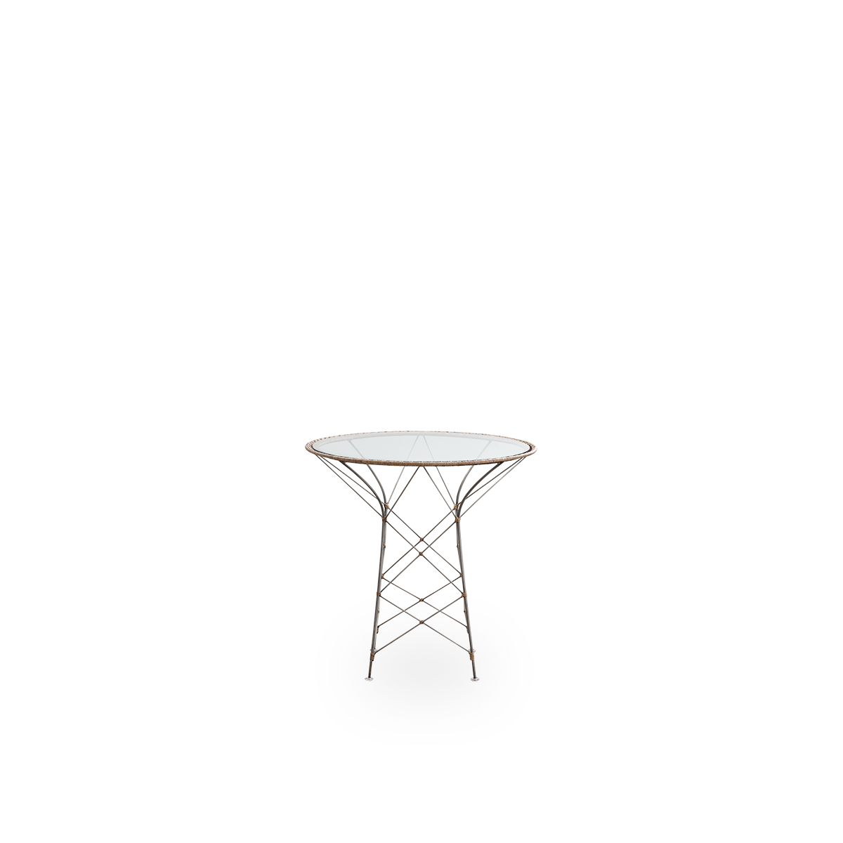 Vista frontal de la mesa de café Funky, diseñada por Yuzuru Yamakawa.
La mesa tiene un tablero de vidrio redondo y una estructura de acero tejida a mano con ratán indonesio en color avellana.