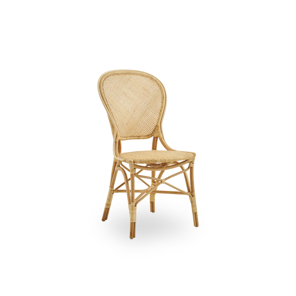 Vista lateral de la silla de comedor Rossini en ratán natural. Elegante silla de mimbre con respaldo redondo de diseño sencillo. Hecha a mano con ratán de alta calidad.