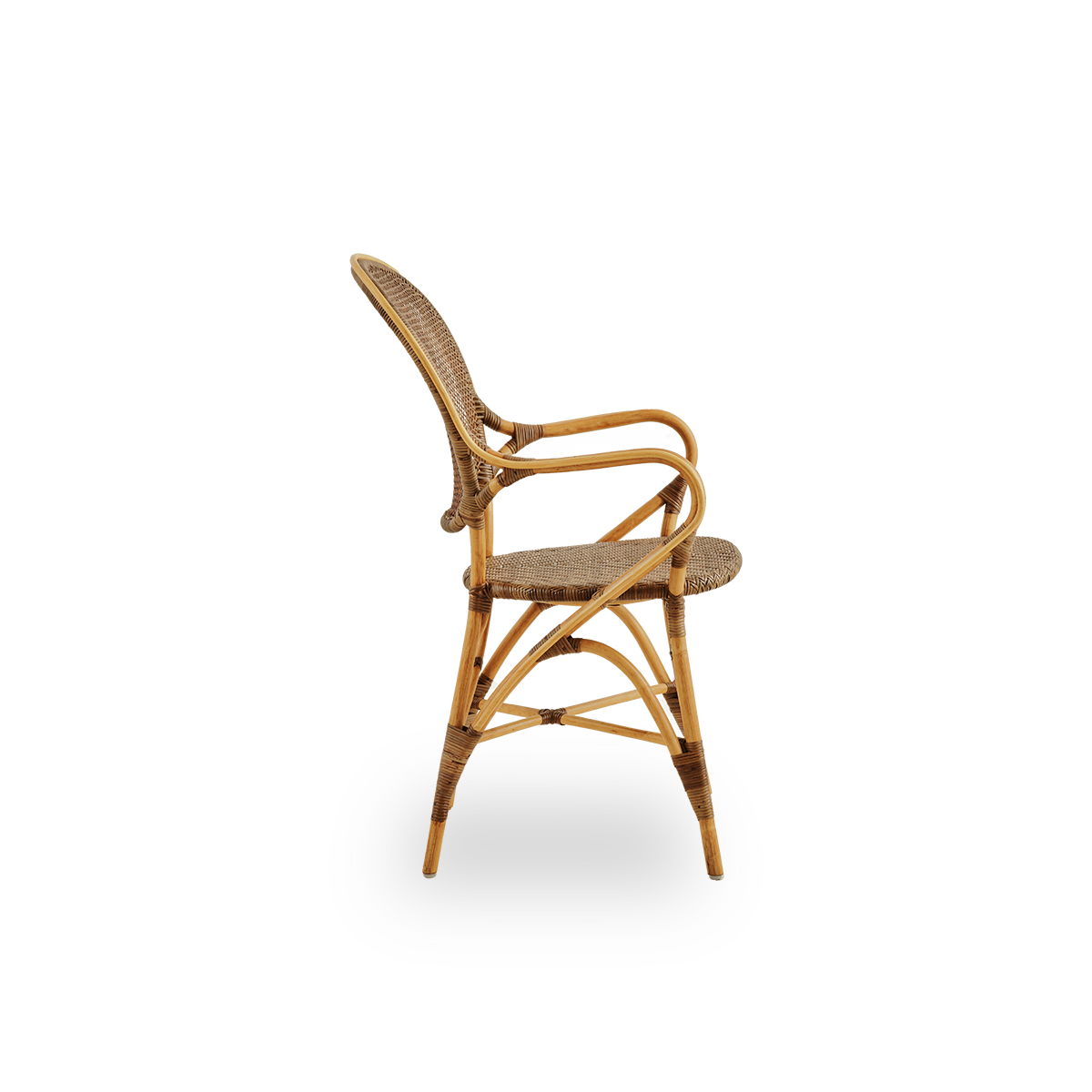 Vista lateral del sillón de comedor Rossini en color cereza. Elegante silla de mimbre con respaldo redondo y reposabrazos de diseño sencillo. Hecha a mano con ratán de alta calidad.