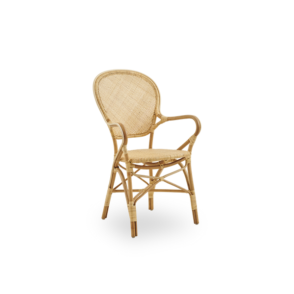 Vista lateral de la silla de comedor Rossini con brazos hecha en ratán natural. Elegante silla de mimbre con respaldo redondo y reposabrazos de diseño sencillo. Hecha a mano con ratán de alta calidad.