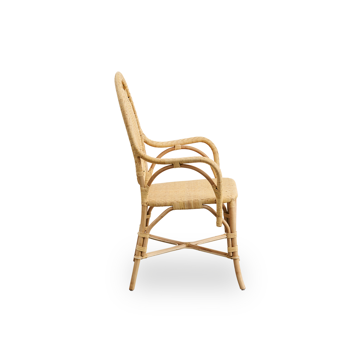 Vista lateral de la silla de comedor Romantica en color natural. Elegante silla de comedor de mimbre romántica con respaldo redondo y asiento completamente tejido en encantador diseño danés. Hecha a mano con ratán indonesio de alta calidad.