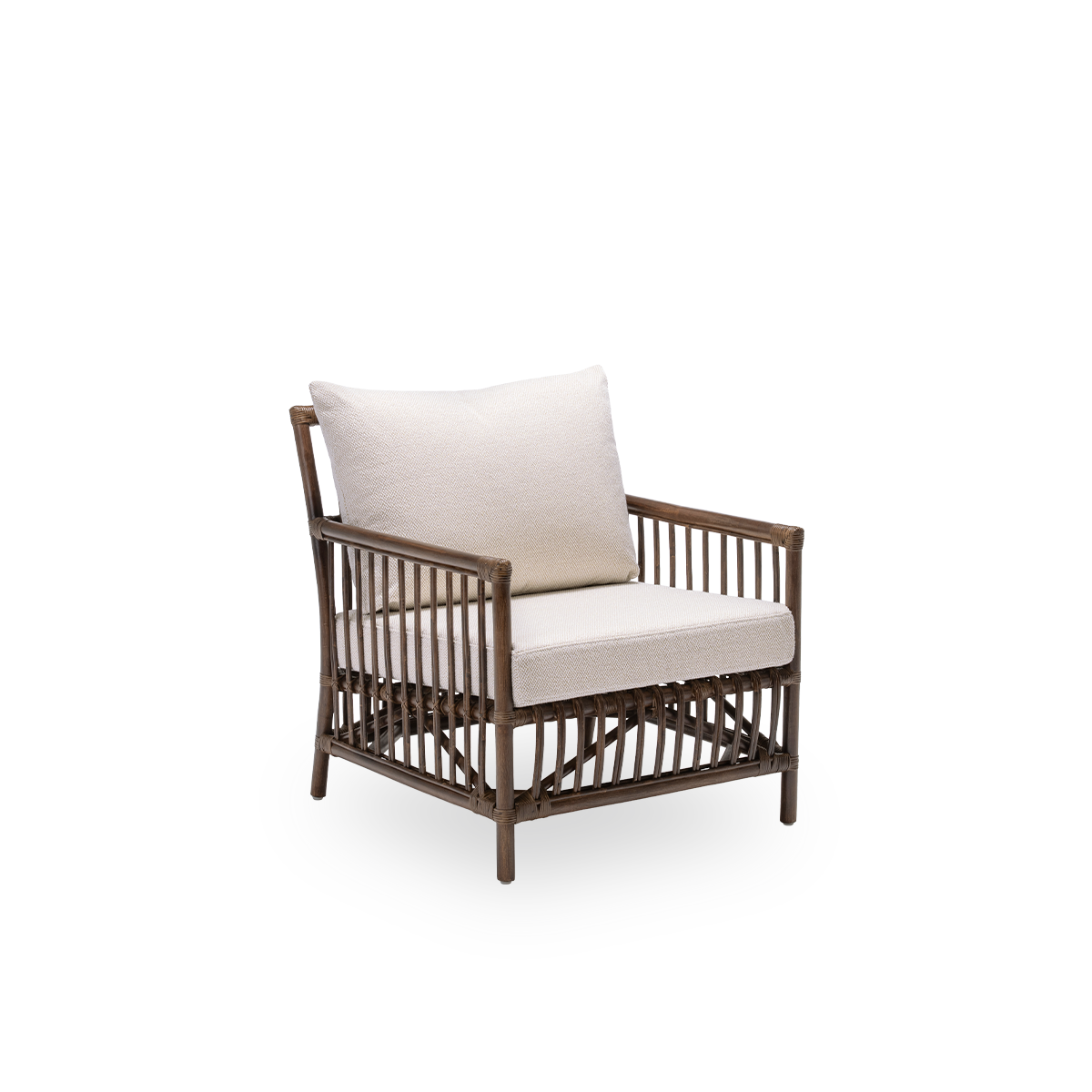 Vista lateral del sillón lounge Caroline con cojines de asiento y respaldo, en ratán marrón. Un diseño danés sencillo y elegante cuyo tejido detallado lo convierte en un elemento sereno de la sala. Hecha a mano con ratán de Indonesia de alta calidad.