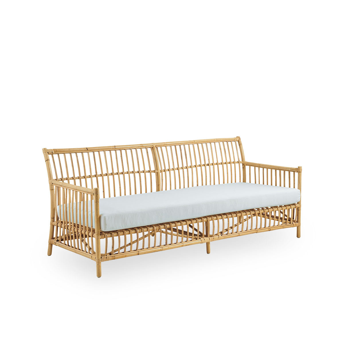 Vista lateral del sofá de mimbre Caroline de 3 plazas, diseño danés simple y elegante. Hecho a mano en ratán indonesio con detalles tejidos que crean una presencia acogedora y relajante.