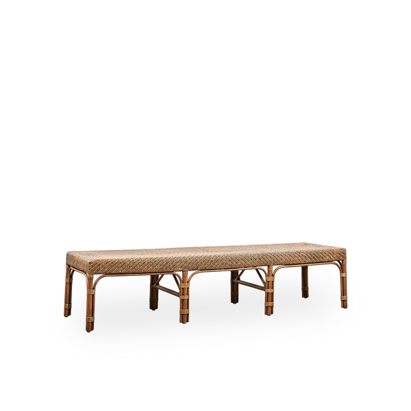 Vista lateral del banco Luis, hecho a mano con ratán de alta calidad de Indonesia en color Antique Brown. Diseño elegante con asiento finamente trenzado. Longitud 180 cm.