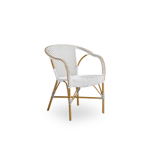 Vista lateral de la silla de comedor exterior Madeleine con brazos. Estructura de aluminio color almendra con asiento y respaldo tejidos en ArtFibre marrón con puntos blancos.