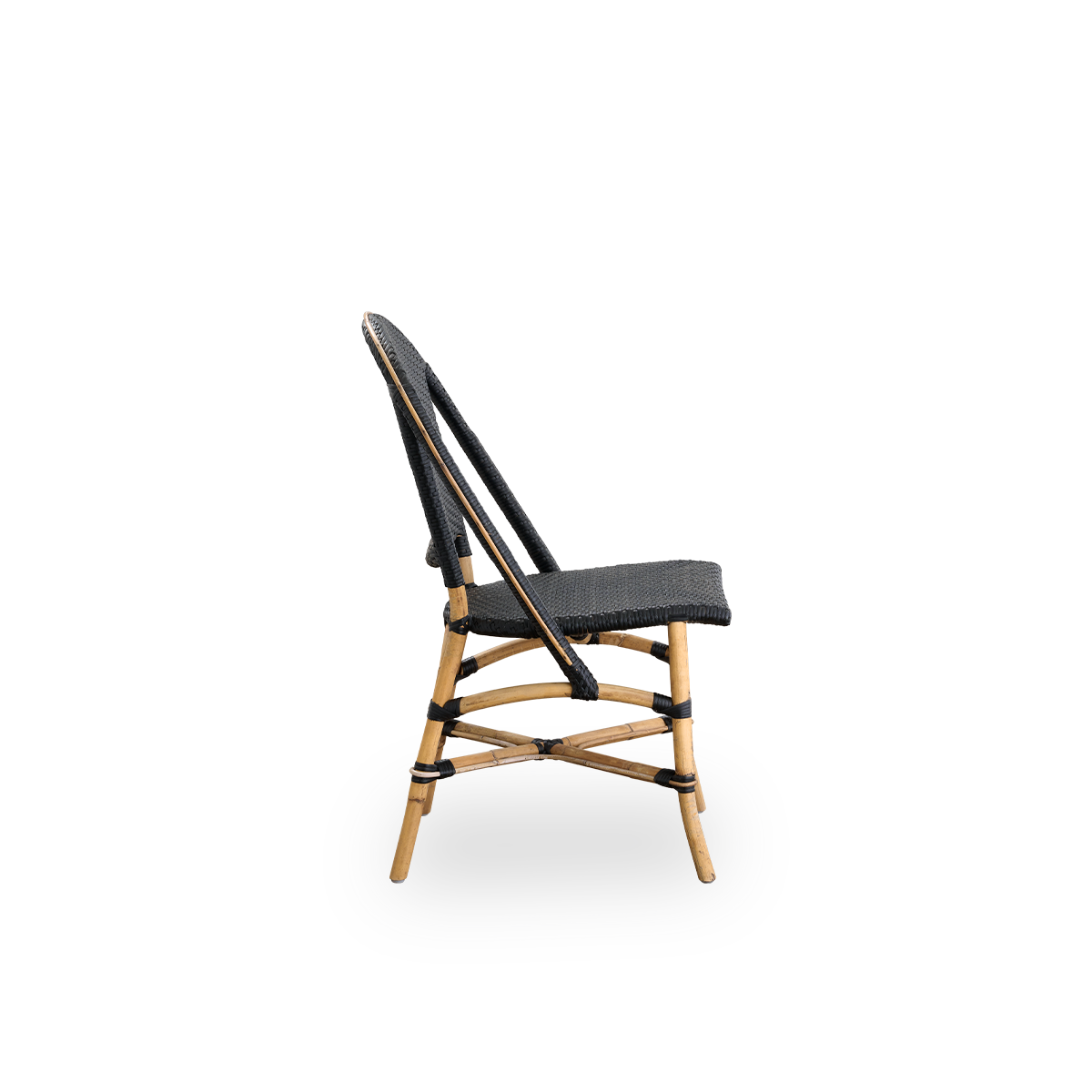 Vista lateral de la silla de comedor Sofie de ratán, inspirada en el estilo de café francés. Estructura de ratán con asiento y respaldo completamente tejidos a mano en ArtFibre de color negro. Silla de bistró de ratán apilable.