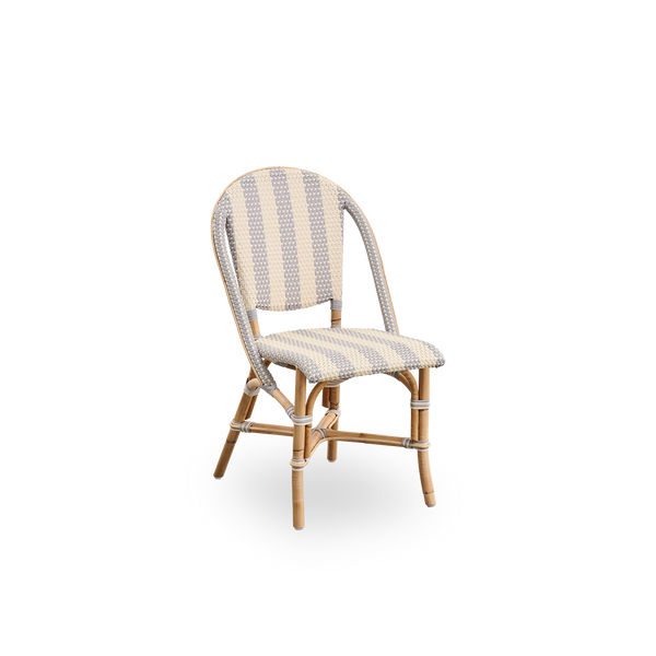 Vista lateral de la silla de comedor Sofie de ratán, inspirada en el estilo de café francés. Estructura de ratán con asiento y respaldo completamente tejidos, hechos a mano en ArtFibre con rayas anchas en marfil y gris. Silla bistró de ratán apilable.