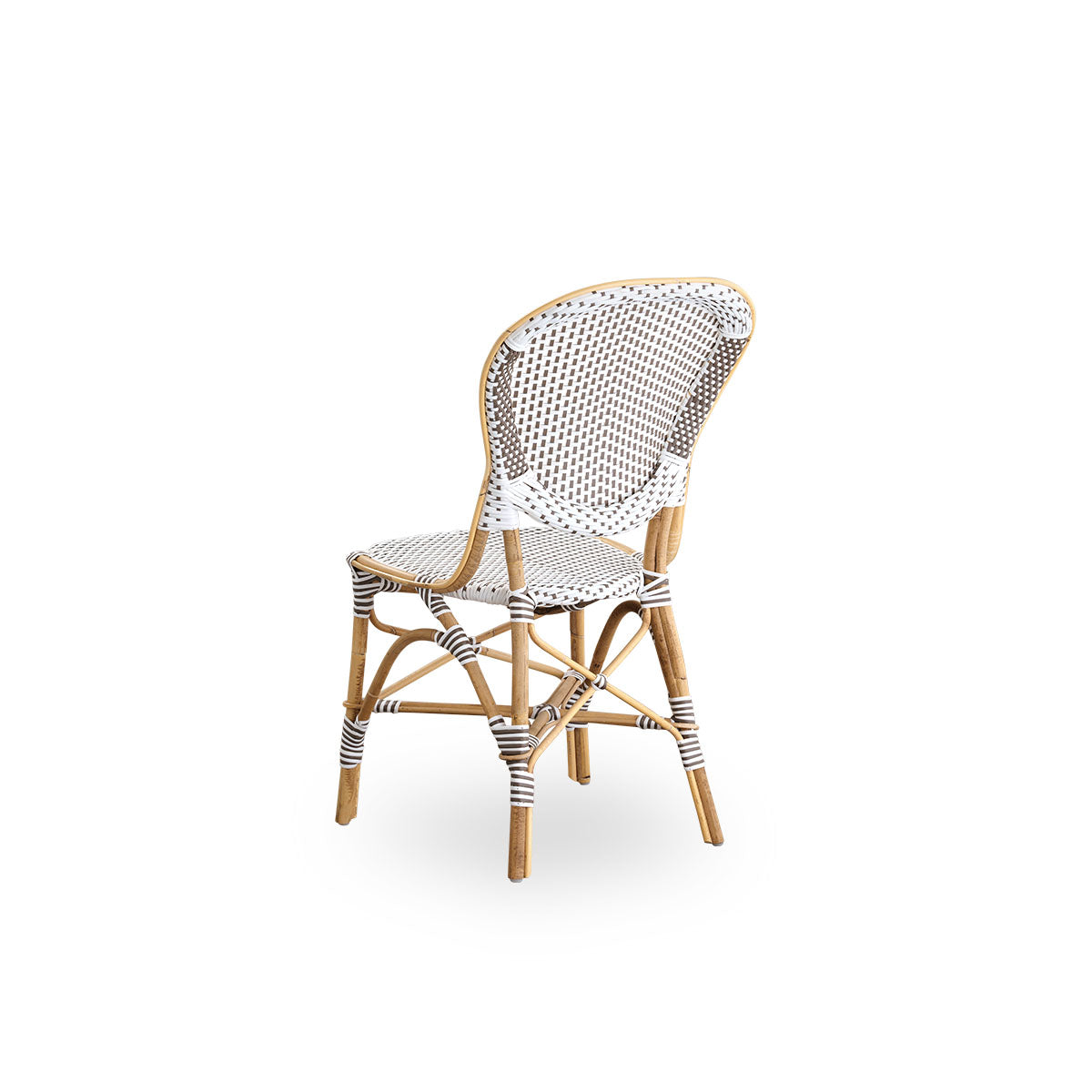 Vista trasera de la silla de comedor Isabell.
Estructura de ratán con asiento y respaldo de ArtFibre blanco con puntos marrones. Inspirada en el diseño de bistró de los años 50.