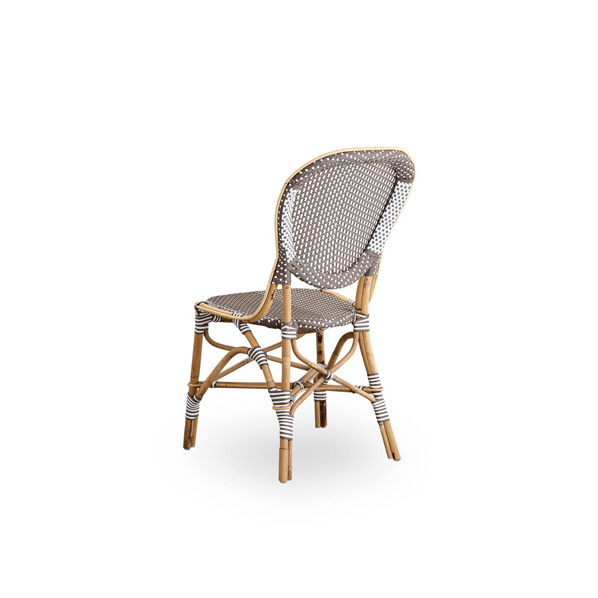 Vista trasera de la silla de comedor Isabell.
Estructura de ratán con asiento y respaldo de ArtFibre marrón con puntos blancos. Inspirada en el diseño de bistró de los años 50.