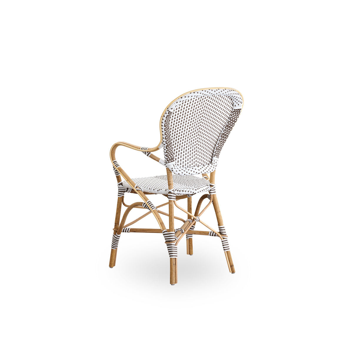 Vista trasera de la silla de comedor Isabell con reposabrazos.
Estructura de ratán con asiento y respaldo de ArtFibre blanco con puntos marrones. Inspirada en el diseño de bistró de los años 50.