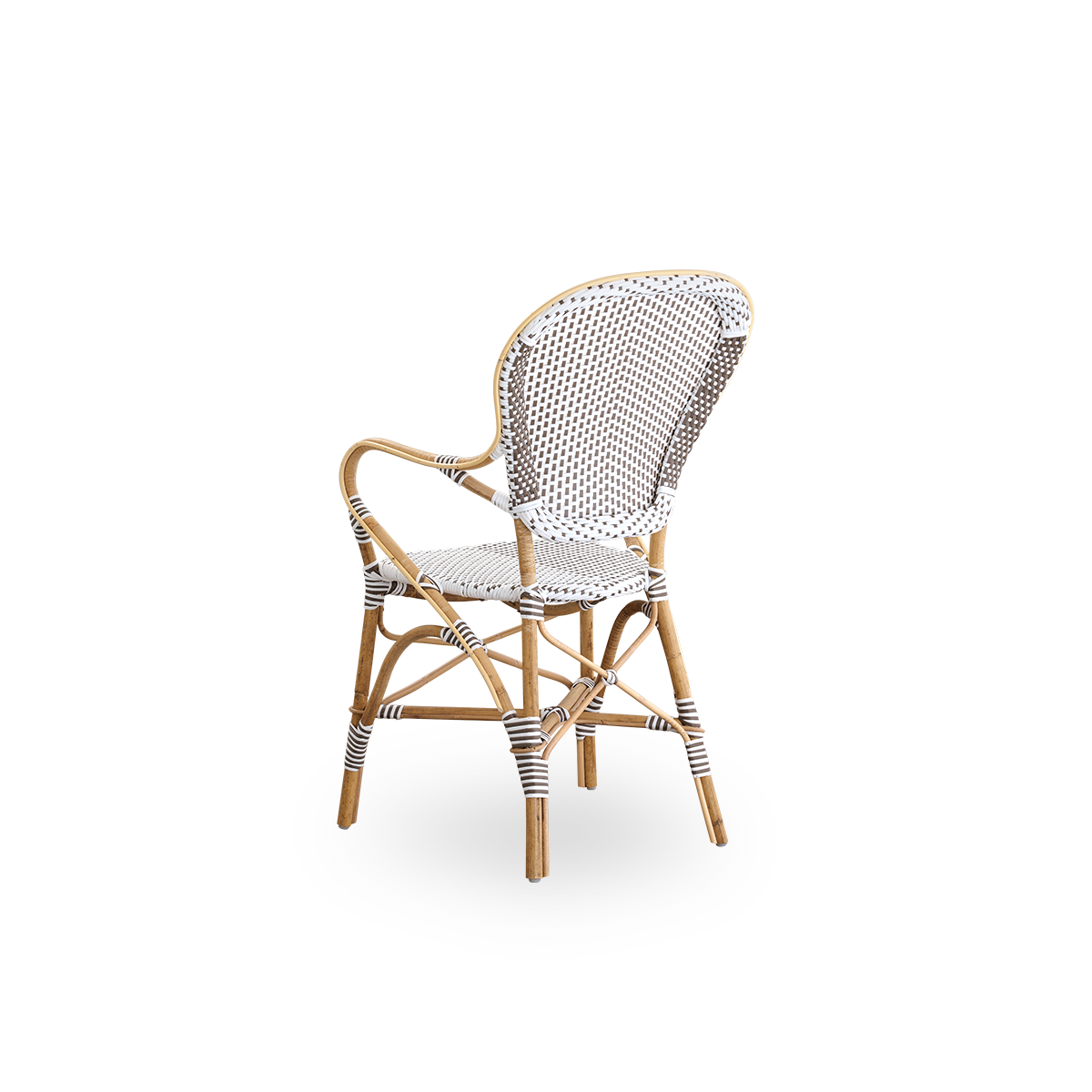 Vista trasera de la silla de comedor Isabell con reposabrazos.
Estructura de ratán con asiento y respaldo de ArtFibre blanco con puntos marrones. Inspirada en el diseño de bistró de los años 50.