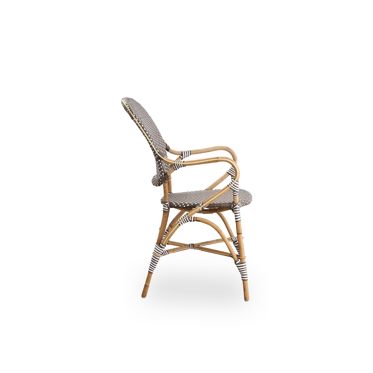 Vista lateral de la silla de comedor Isabell con reposabrazos. Estructura de ratán con asiento y respaldo en ArtFibre marrón con puntos blancos. Inspirado en el diseño de bistró de los años 50.