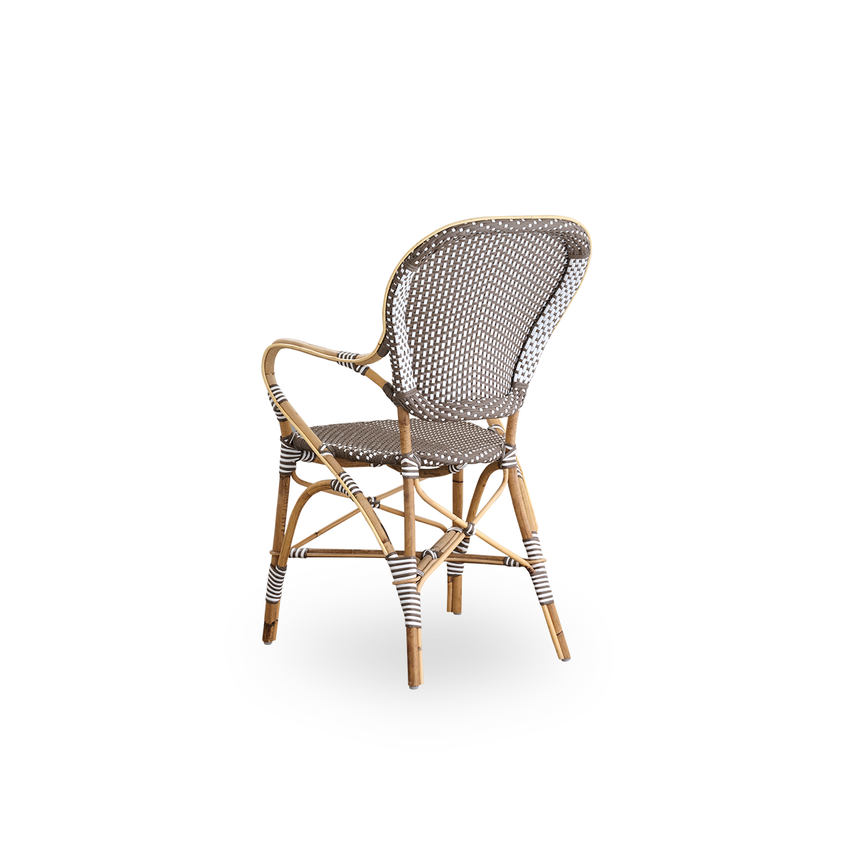 Vista trasera de la silla de comedor Isabell con reposabrazos.
Estructura de ratán con asiento y respaldo de ArtFibre marrón con puntos blancos. Inspirada en el diseño de bistró de los años 50.