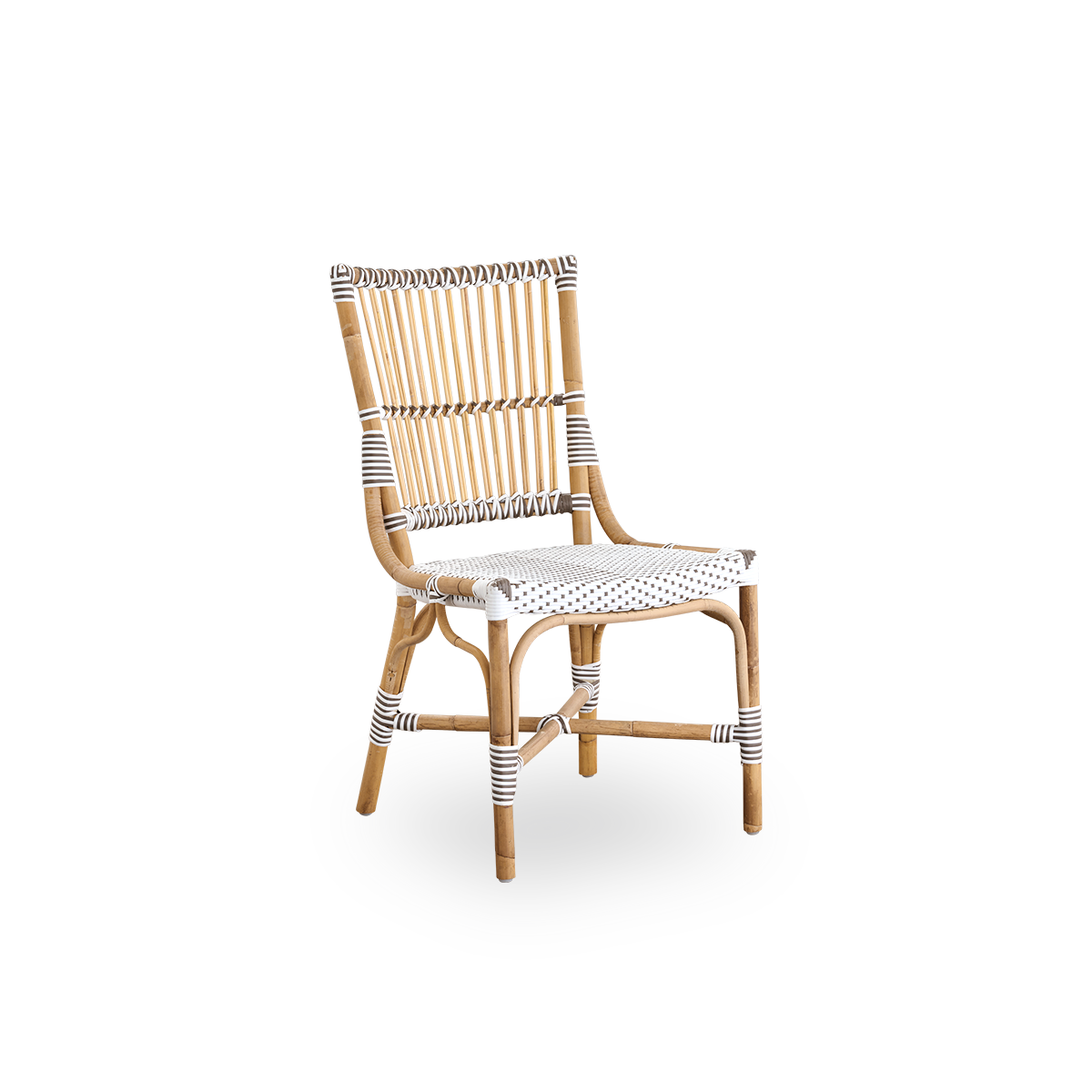Vista lateral de la silla de comedor Monique. Estructura de ratán con asiento tejido en ArtFibre blanco con puntos marrones. Inspirada en el diseño de bistró de los años 50.