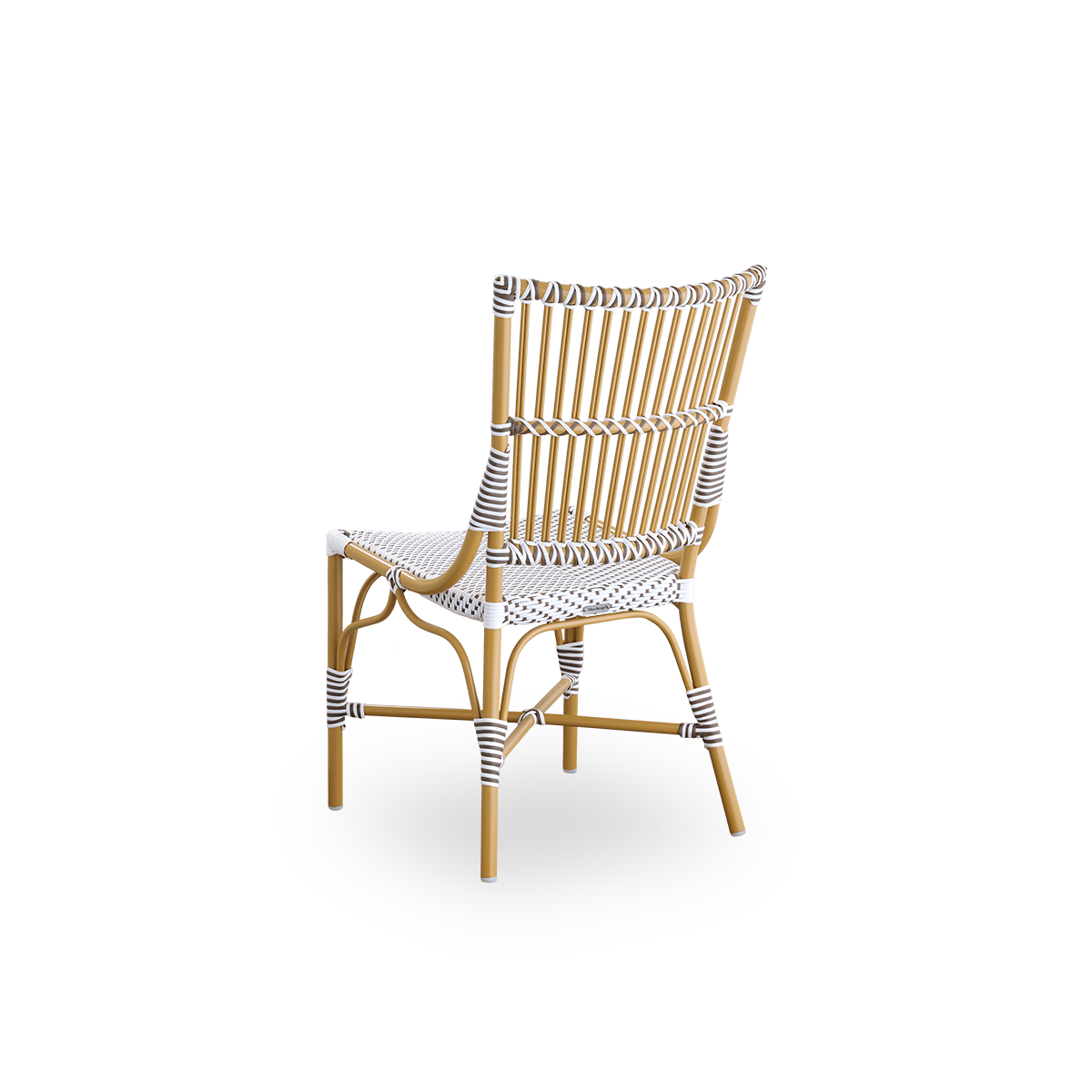 Vista trasera de la silla de comedor Monique.
Estructura de ratán con asiento tejido en ArtFibre blanco con puntos marrones. Inspirada en el diseño de bistró de los años 50.