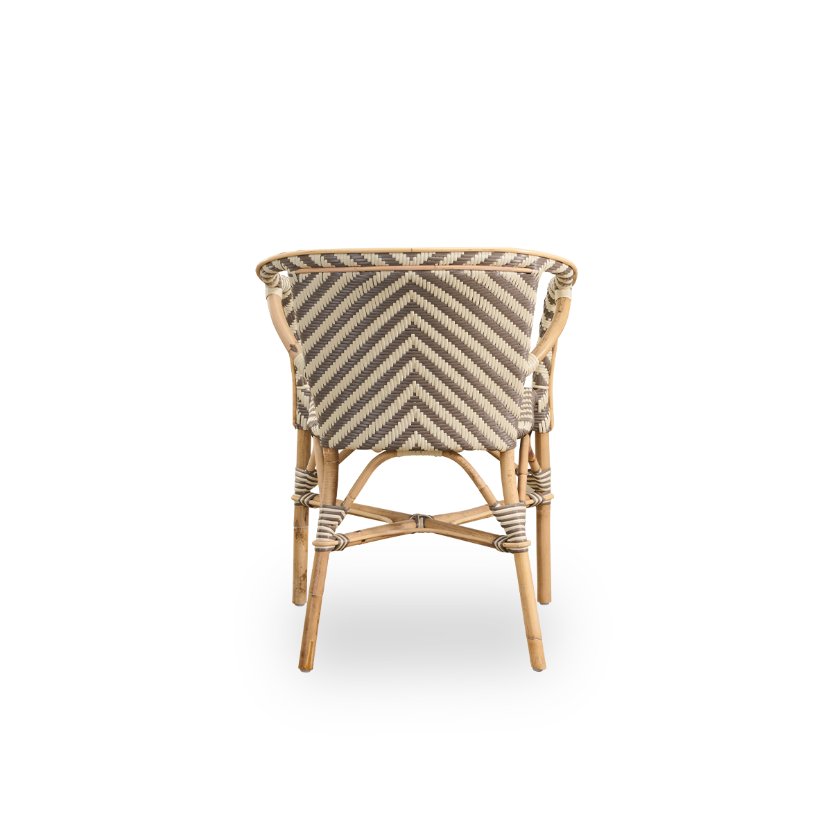 Vista desde atrás de la silla de comedor Madeleine con reposabrazos. Estructura de ratán con asiento y respaldo tejidos en ArtFibre con un patrón de espiga en color marfil y marrón. Inspirada en el diseño de bistró de los años 50.
