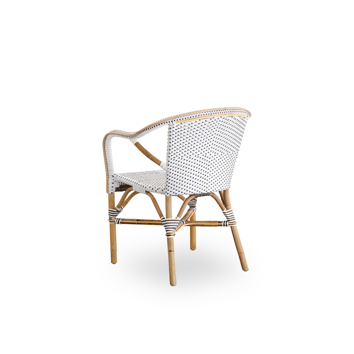 Vista trasera de la silla de comedor Madeleine con reposabrazos.
Estructura de ratán con asiento y respaldo tejidos en ArtFibre blanco con puntos marrones. Inspirada en el diseño de bistró de los años 50.