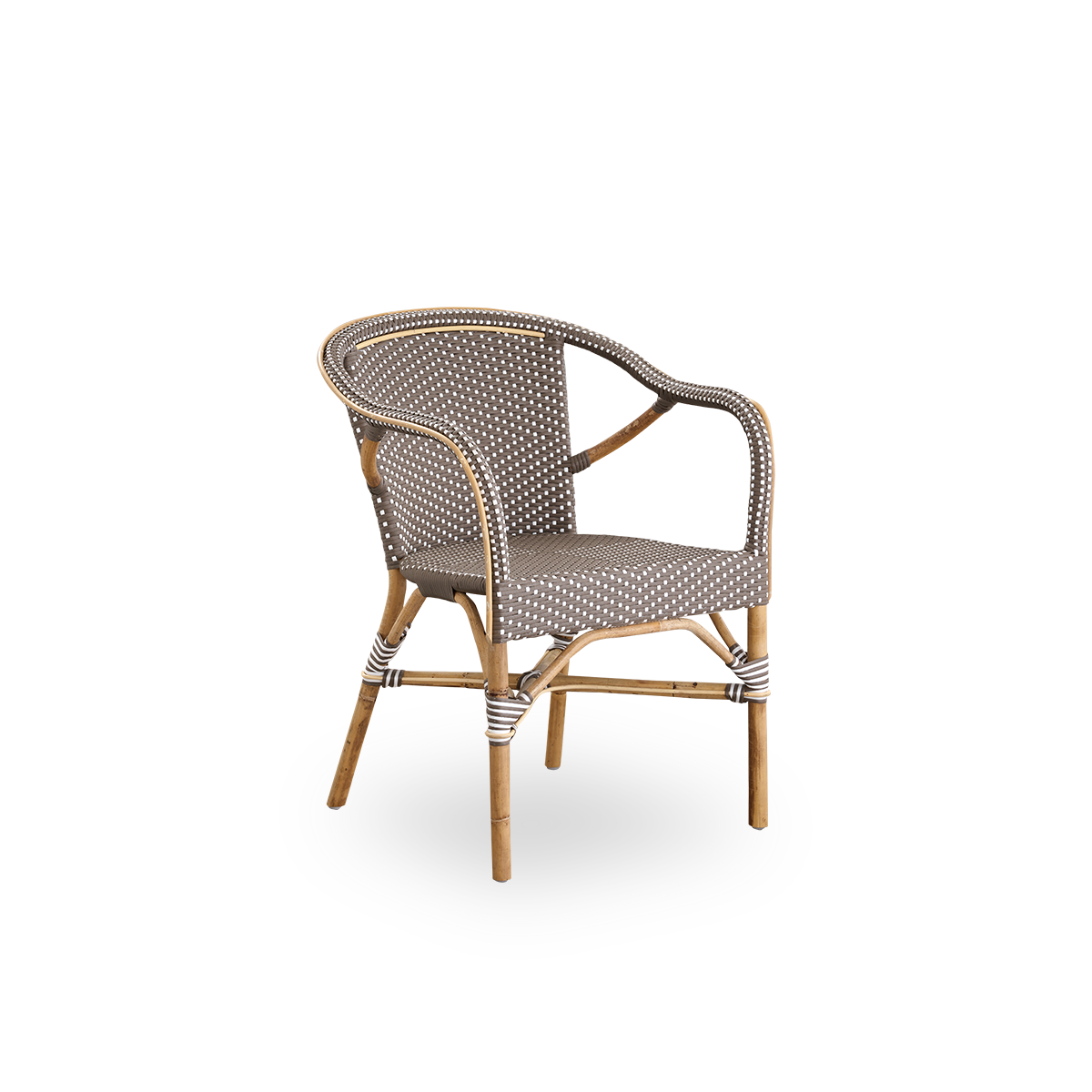 Vista lateral de la silla de comedor con brazos Madeleine. Estructura de ratán con asiento y respaldo tejidos en ArtFibre marrón con puntos blancos. Inspirada en el diseño de bistró de los años 50.