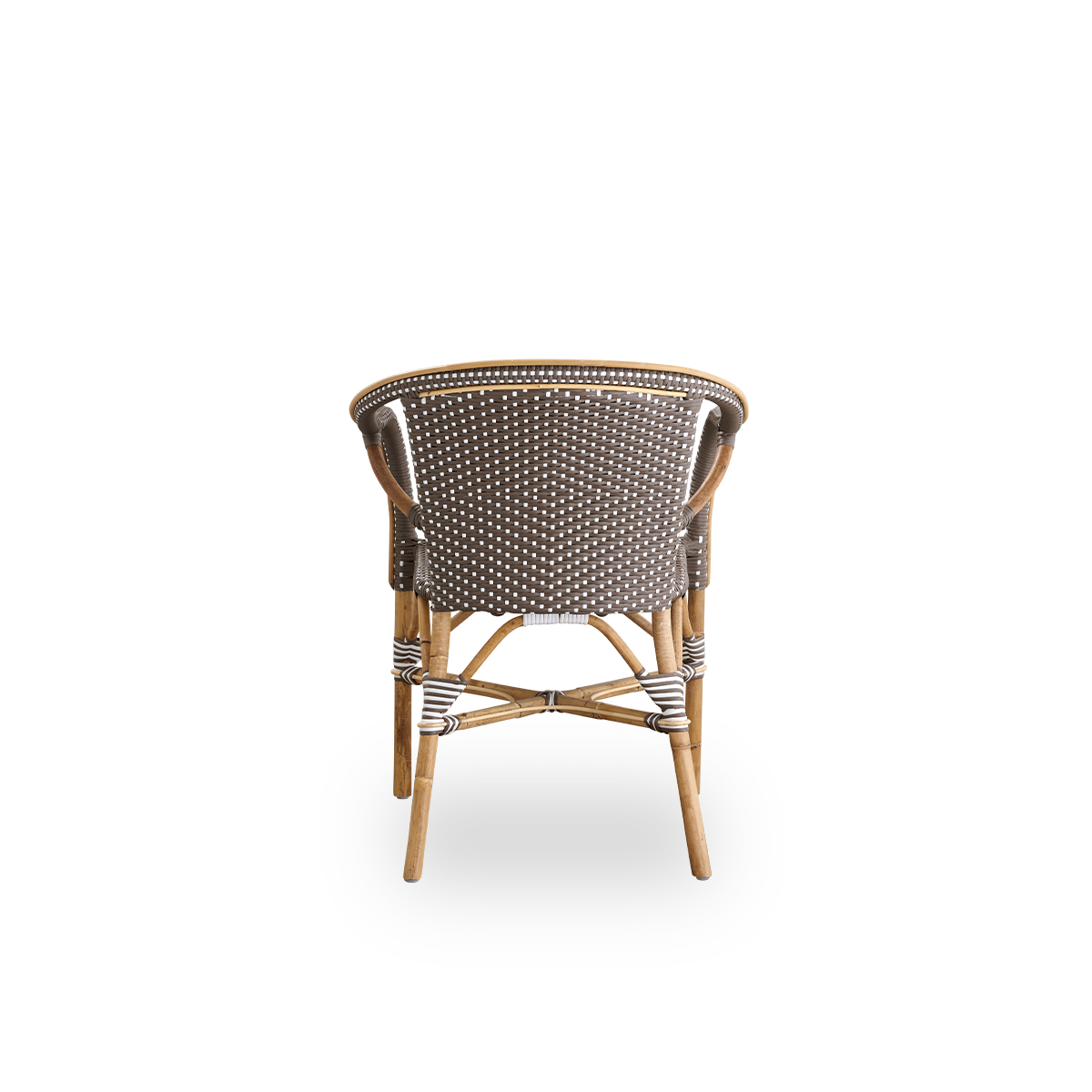 Vista desde atrás de la silla de comedor Madeleine con reposabrazos. Estructura de ratán con asiento y respaldo tejidos en ArtFibre marrón con puntos blancos. Inspirada en el diseño de bistró de los años 50.