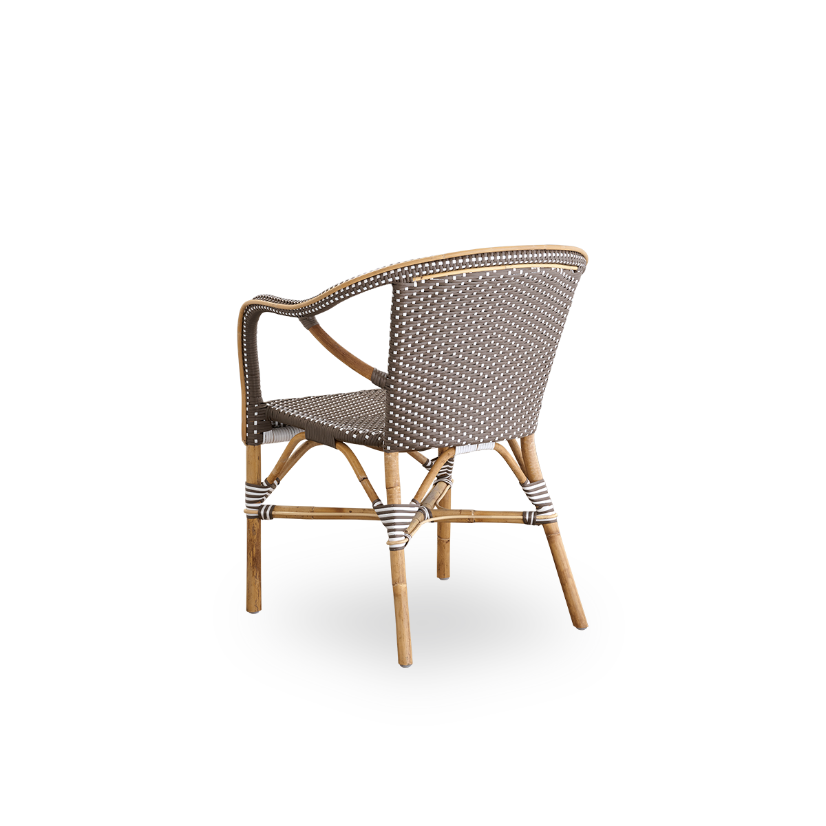 Vista trasera de la silla de comedor Madeleine con reposabrazos.
Estructura de ratán con asiento y respaldo tejidos en ArtFibre marrón con puntos blancos. Inspirada en el diseño de bistró de los años 50.