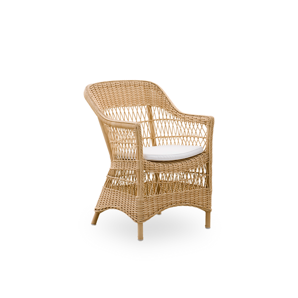 Vista lateral de la silla de comedor exterior Charlot en color natural, una silla exterior totalmente tejida al estilo colonial británico, hecha a mano con ArtFibre sobre estructuras de aluminio duraderas.