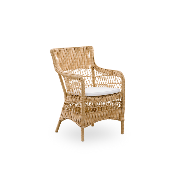 Vista lateral de la silla de comedor exterior Marie con reposabrazos en color Natural. Estructura de aluminio completamente tejida con ArtFibre, inspirada en el estilo colonial británico.