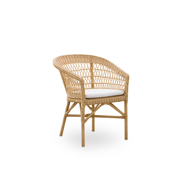 Vista lateral de la silla de comedor exterior Emma en color Natural, inspirada en el estilo colonial británico. Respaldo redondo que se convierte en reposabrazos. Estructura de aluminio totalmente tejida con ArtFibre.