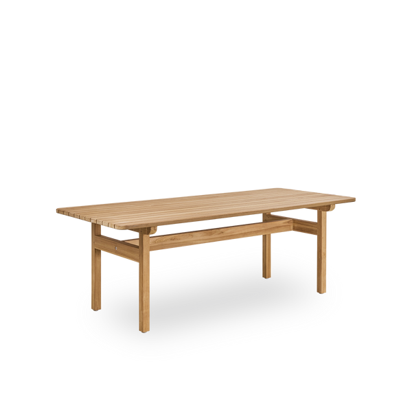 Vista lateral de la mesa de exterior Tobias de teca, diseñada por Arne Jacobsen, tamaño 205x91 cm. Hecha a mano en madera de teca indonesia de alta calidad y certificada.