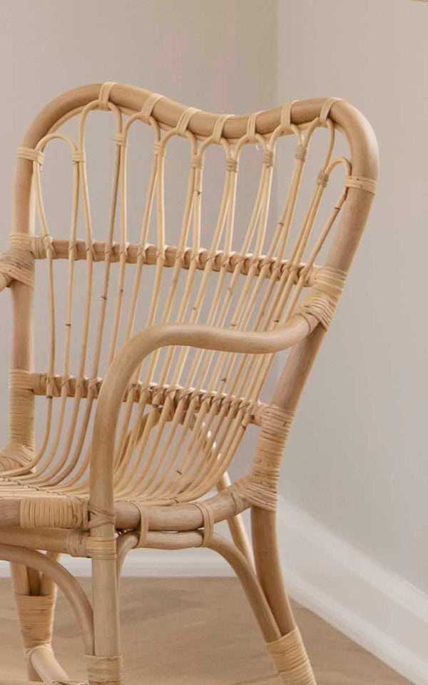 Esta es una imagen de detalle de Margret silla de comedor en natural rattan. El respaldo tejido a mano y el marco curvado destacan la artesanía.