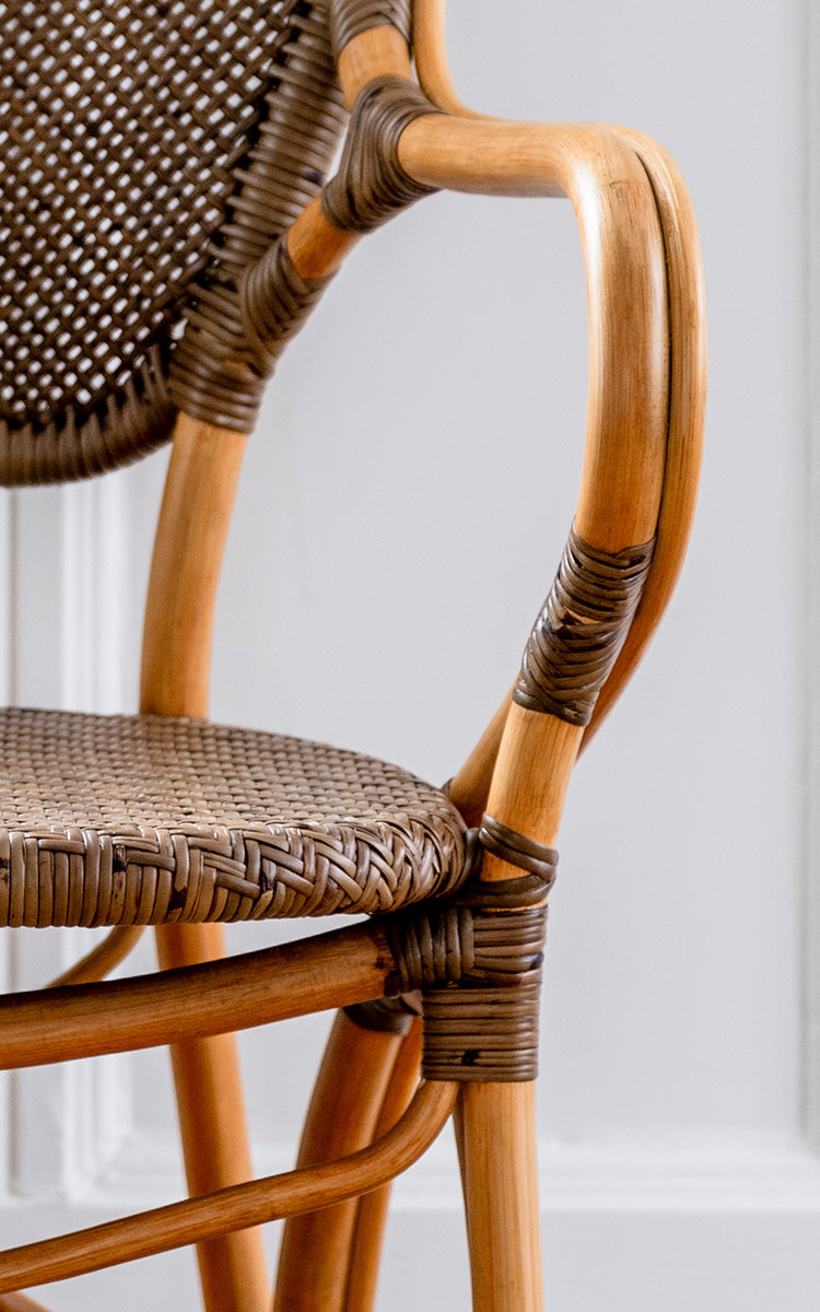 Esta es una imagen de detalle de Rossini sillón en cherry rattan. Respaldo de caña cereza a dos tonos con estructura curva natural y asiento tejido.