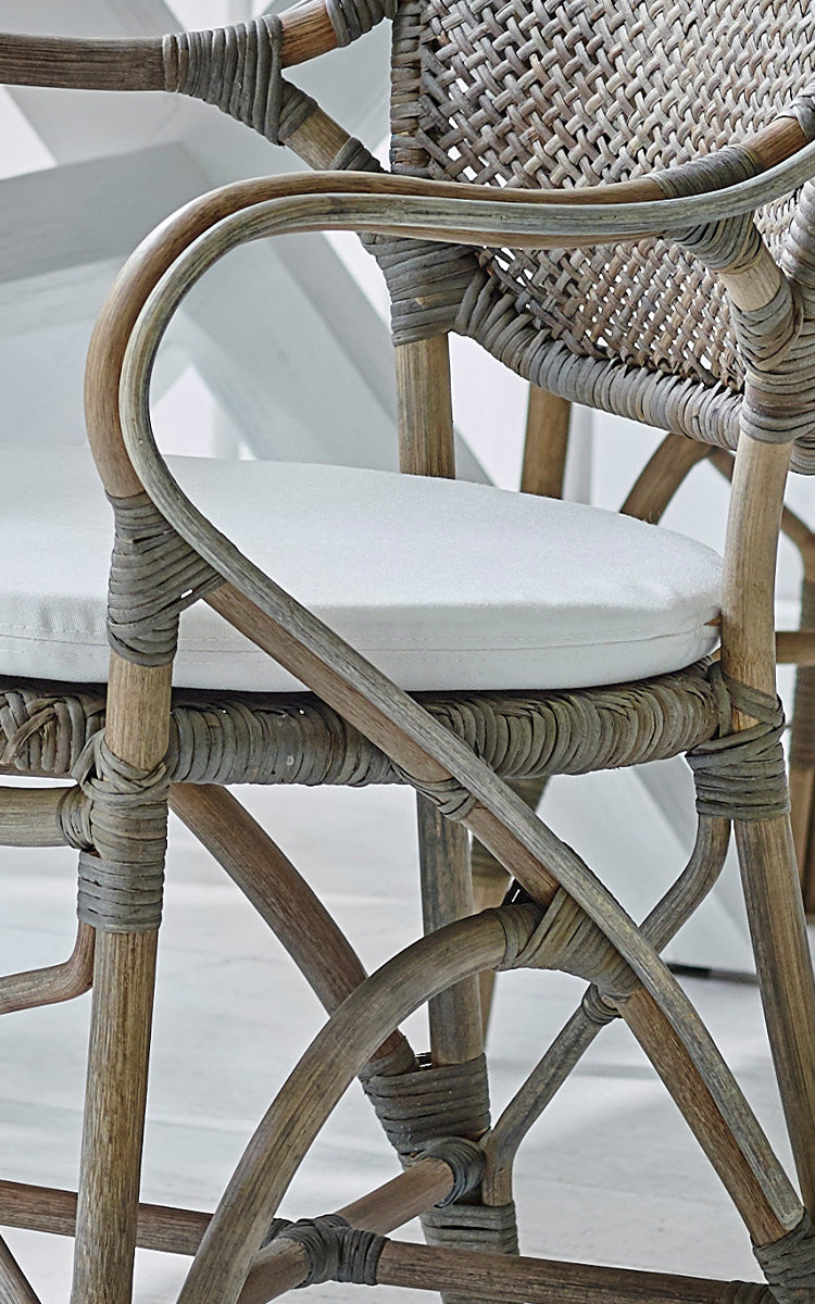 Esta es una imagen de detalle de Rossini sillón en taupe rattan. Detalle del ratán taupe envejecido con cojín de asiento blanco.