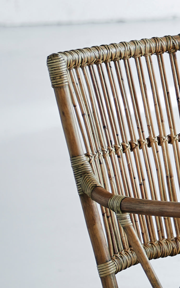 Esta es una imagen de detalle de Piano silla de comedor en antique rattan. Detalle del respaldo con husillos verticales de ratán y uniones envueltas.