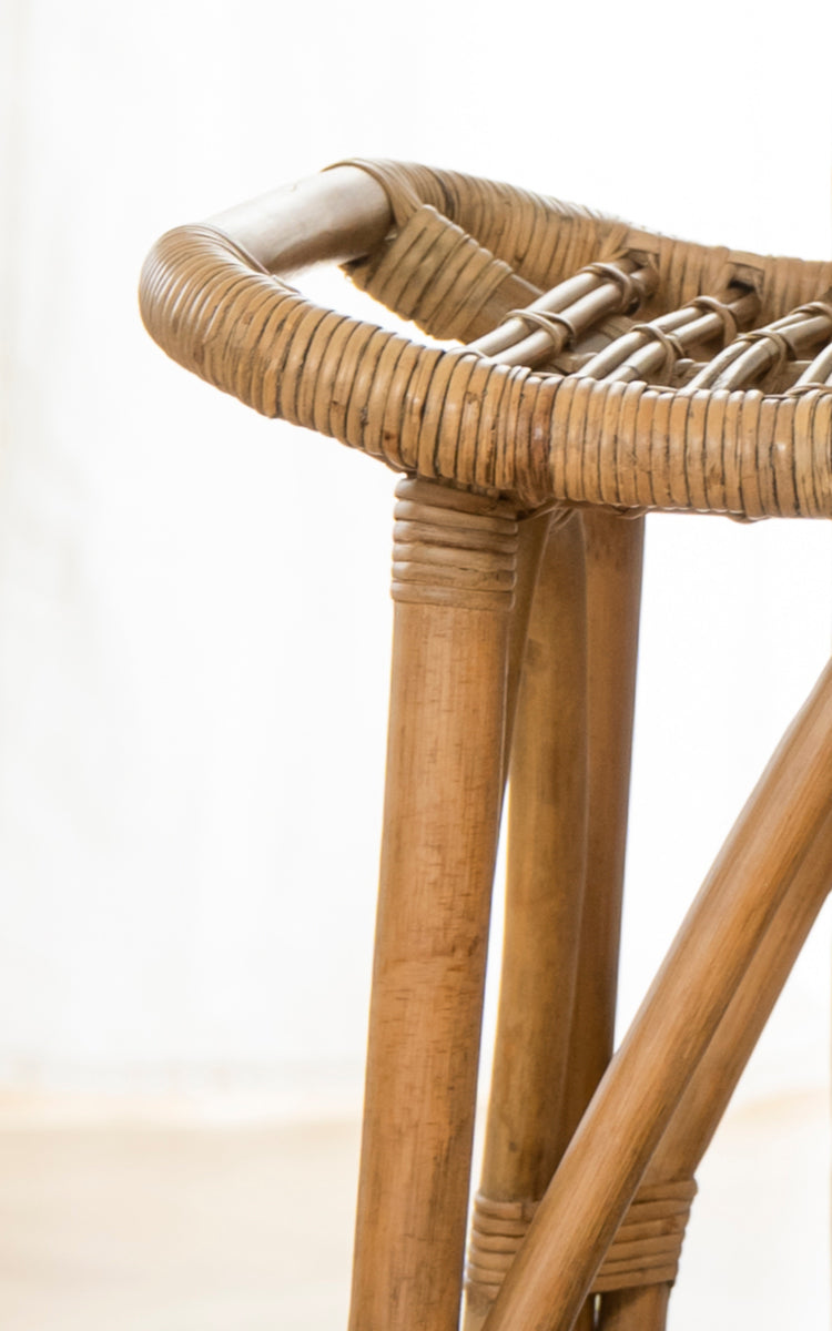 Esta es una imagen de detalle de Salsa taburete de bar en antique rattan. Detalle de la base trípode de ratán y borde envuelto del asiento redondo.