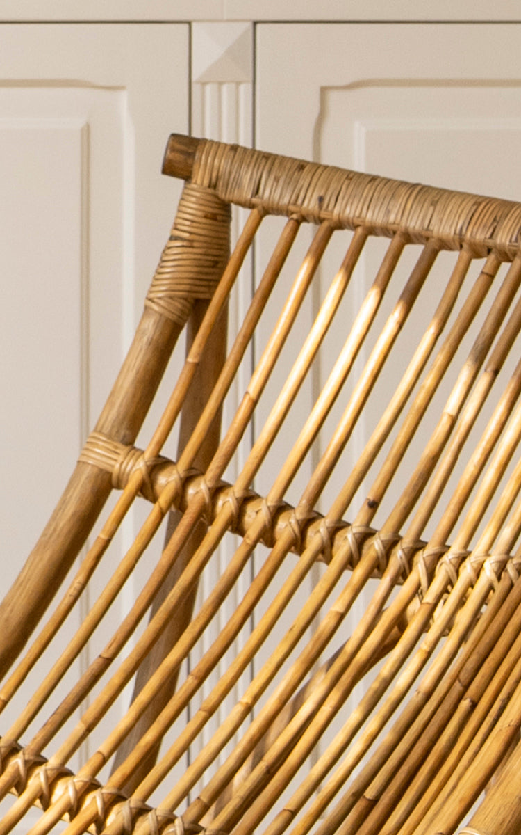Esta es una imagen de detalle de Michelangelo Daybed i antique rattan. Detalle de la construcción curva escultural de varillas de ratán y las uniones envueltas.