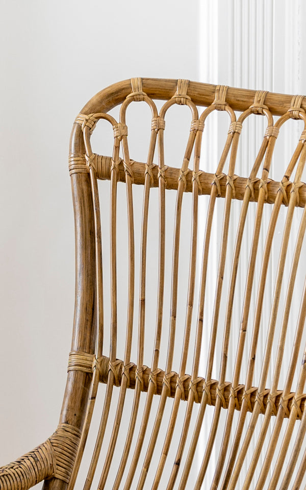 Esta es una imagen de detalle de Monet Rocking Chair i antique rattan. Detalle del respaldo de arcos en bucle y la construcción de varillas verticales de ratán.
